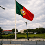 Portuguese flag flying in Lisbon under a cloudy winter sky, symbolizing arrival and the start of a week working remotely in Portugal.